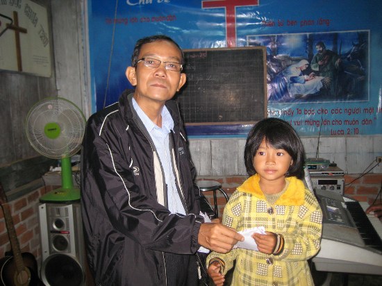 Mục sư Phạm Hơn trao học bỗng của Đoàn Từ Thiện Giô-sép cho một em học sinh người K’ho ở Lâm Đồng